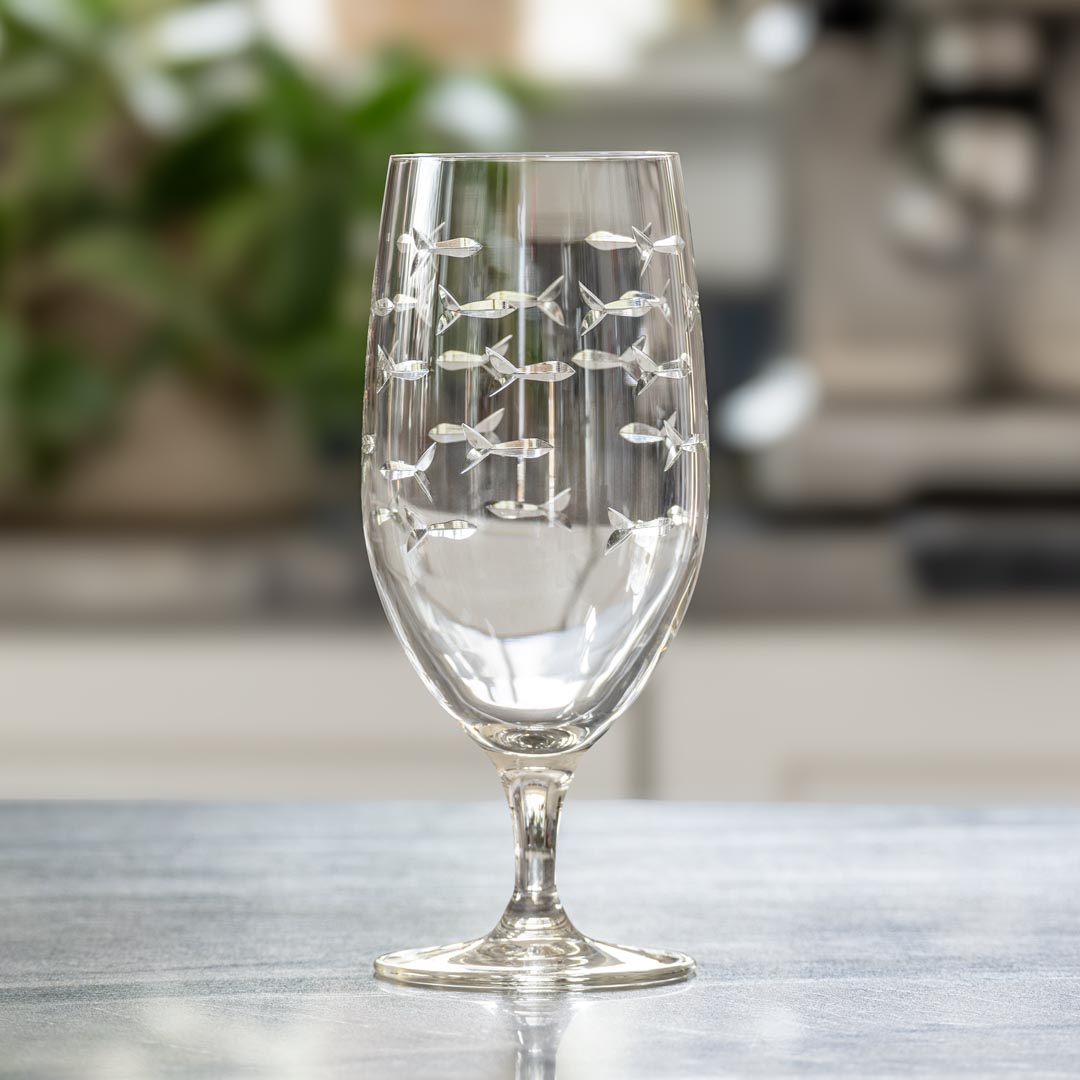 Rolf Glass School of Fish 16oz Footed Iced Tea Glass empty on kitchen counter