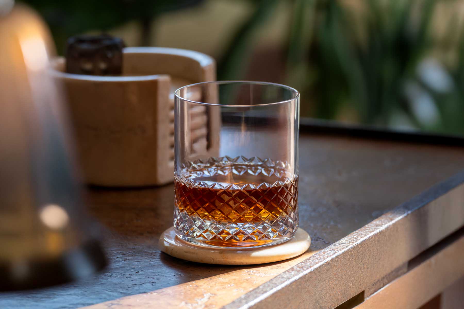 Glass of whiskey on a coaster with a blurred background