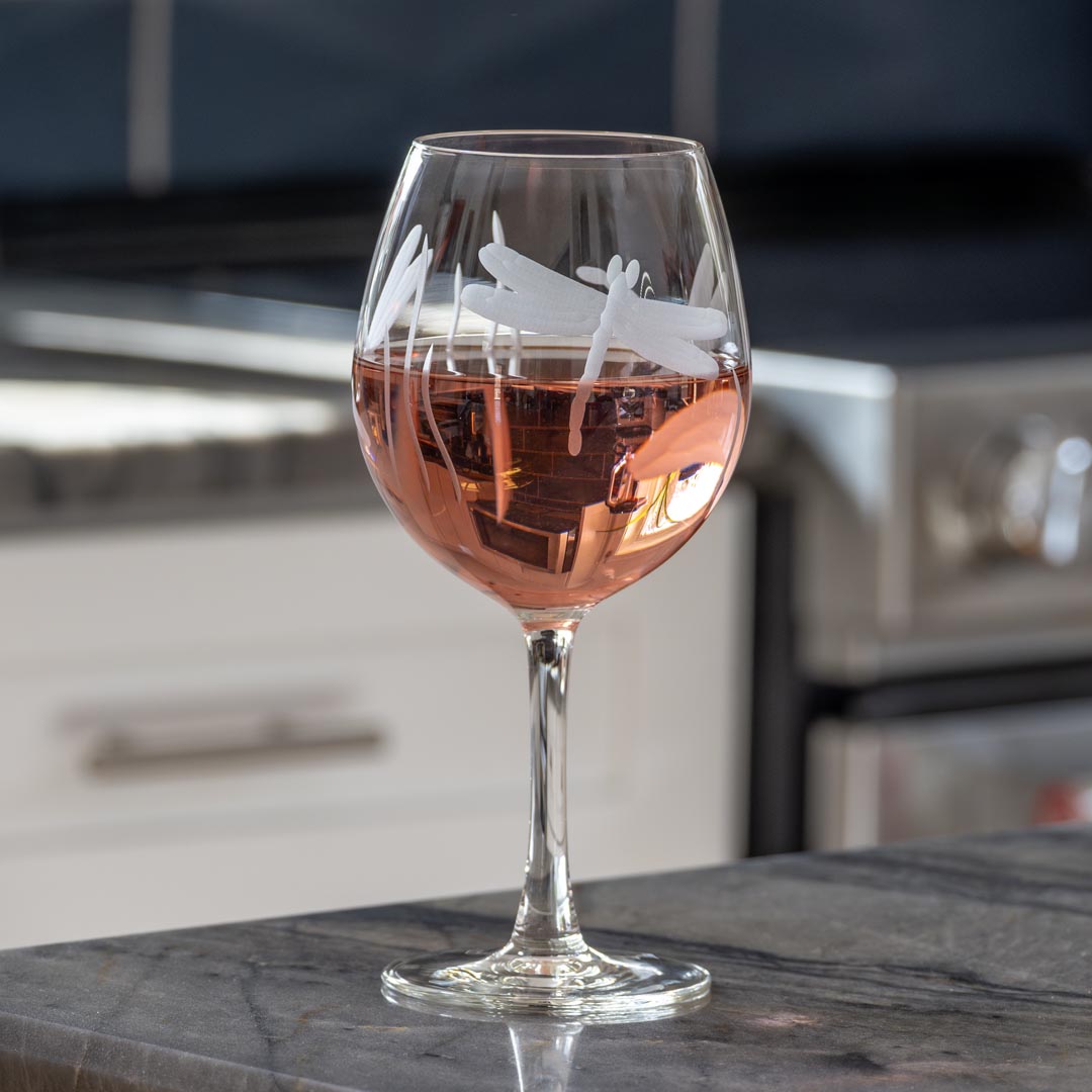 Rolf Glass Dragonfly 18oz Balloon Red Wine Glass filled with red wine on a kitchen counter top