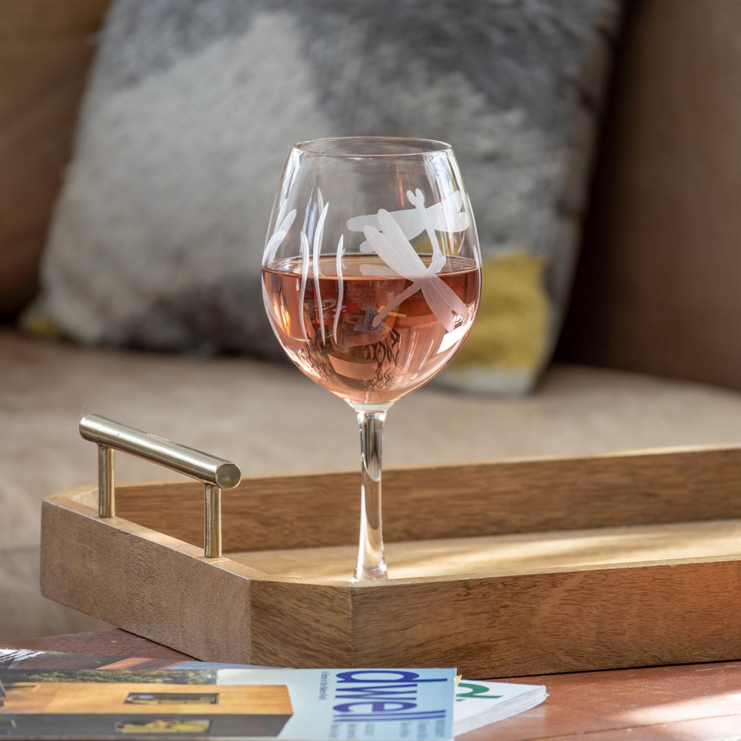 Rolf Glass Dragonfly 18oz Balloon Red Wine Glass filled with red wine on a coffee table