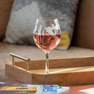 Rolf Glass Dragonfly 18oz Balloon Red Wine Glass filled with red wine on a coffee table