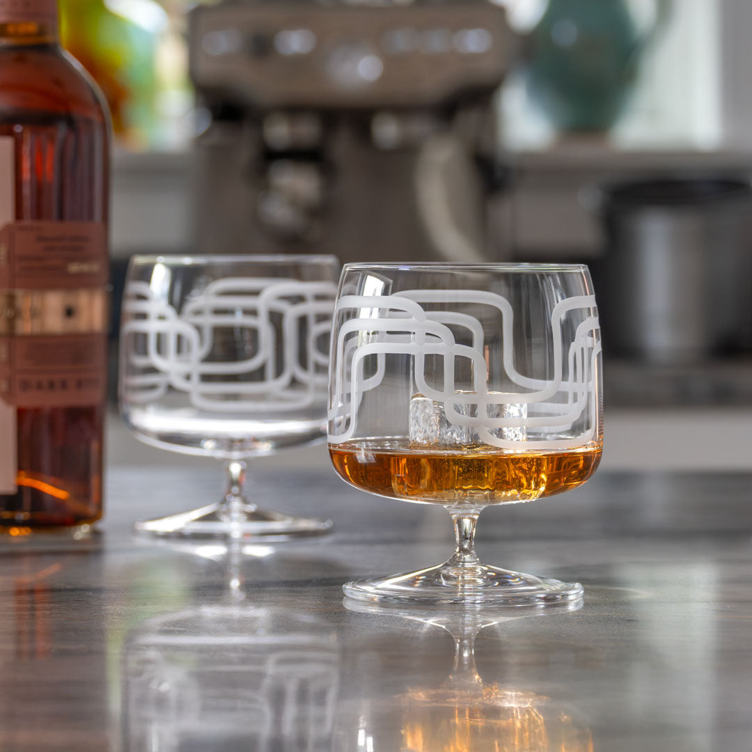 Mid Century Modern 17oz Footed Rocks Cocktail Glass with a bourbon cocktail