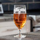 Rolf Glass Palm Tree 16oz Footed Iced Tea glass full of iced tea on kitchen counter top