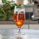 Rolf Glass Palm Tree 16oz Footed Iced Tea glass full of iced tea on kitchen counter top