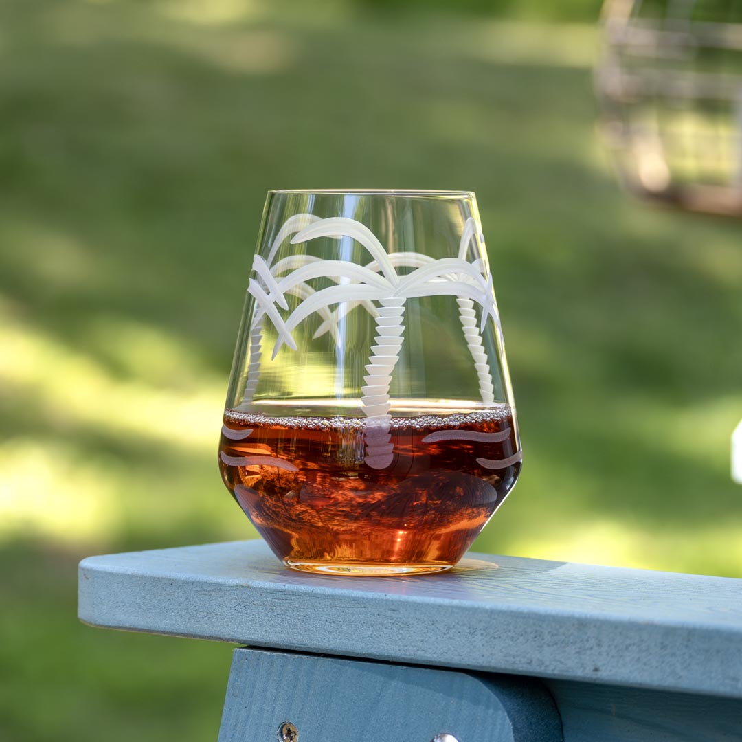 Rolf Glass Palm Tree 18oz Stemless Wine Tumbler on the patio
