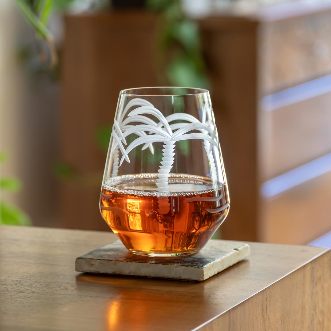 Rolf Glass Palm Tree 18oz Stemless Wine Tumbler on a desk