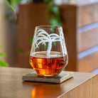 Rolf Glass Palm Tree 18oz Stemless Wine Tumbler on a desk