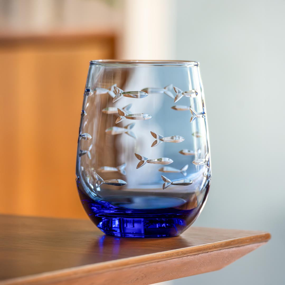 Rolf Glass School of Fish 15oz Blue Stemless Wine Glass on a dining room table