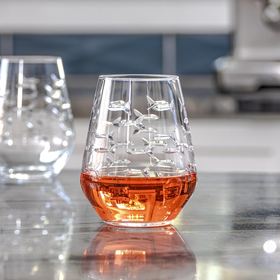 Rolf Glass School of Fish 18oz Stemless Wine Tumbler Glass filled with red on a granite kitchen counter