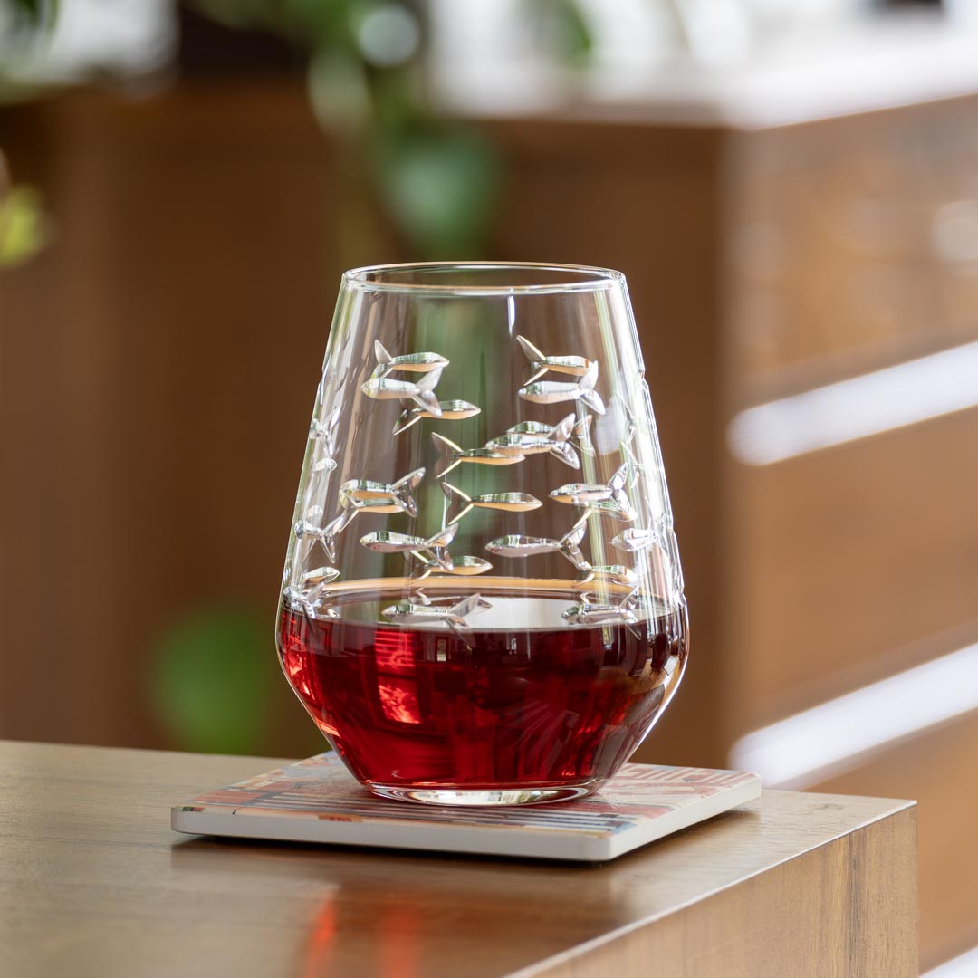 Rolf Glass School of Fish 18oz Stemless Wine Tumble Glass on a desk