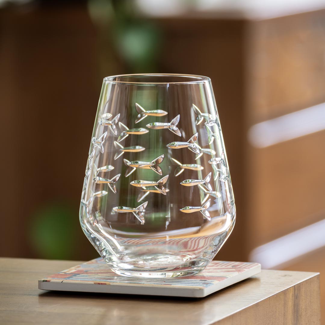 Rolf Glass School of Fish 18oz Stemless Wine Tumble Glass on a desk