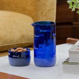 Rolf Glass School of Fish Twice Around Blue 13oz Pitcher and 2 Inch Mini Sipper Giftbox Set on a coffee table